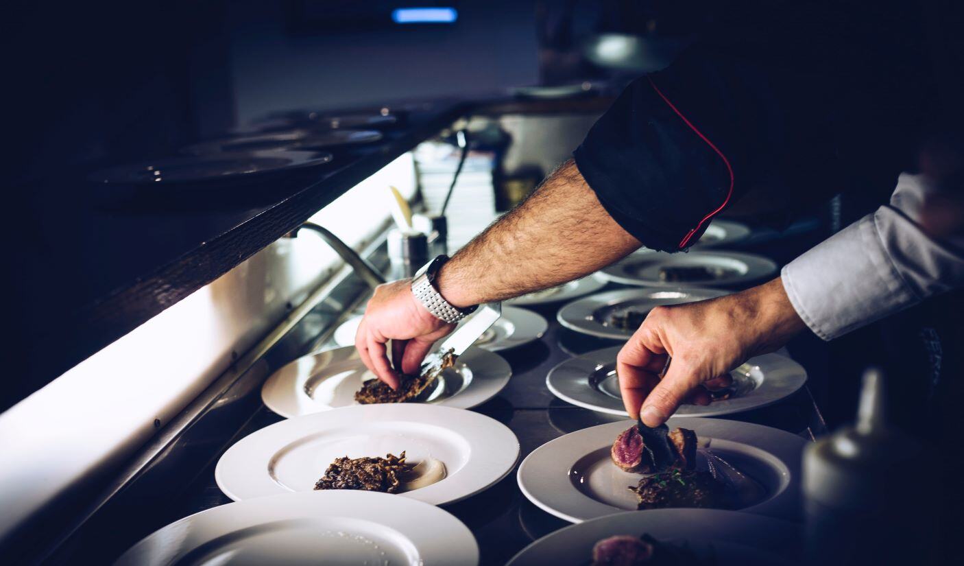 cuisine d_un restaurant avec mains préparant des assiettes gastronomiques